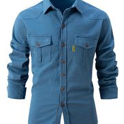 Blue denim shirt with two front pockets on a white background
