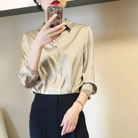Champagne satin blouse worn by a model taking a mirror selfie.