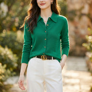 Green sweater worn by a person with a blurred background