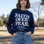 Navy sweatshirt with 'Faith Over Fear' text on a wooden background