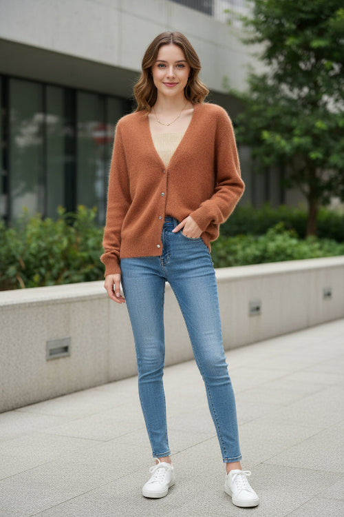 A fuzzy, soft-textured cardigan sweater in a warm rust or terracotta orange-brown color, worn over a beige ribbed top. 