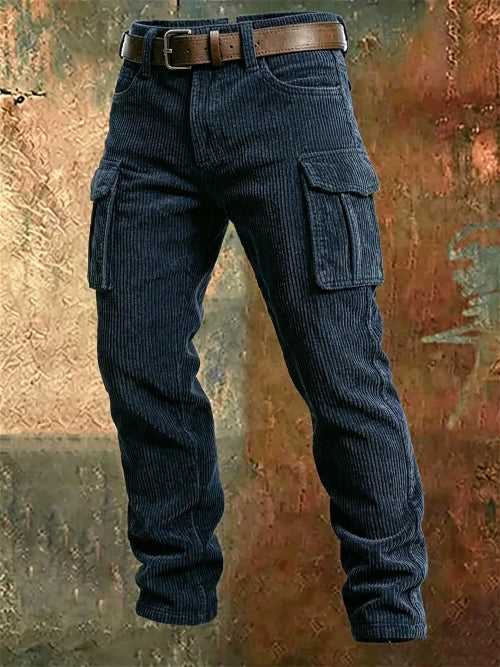 Navy blue corduroy cargo pants with flap thigh pockets and a brown belt against a textured rust-colored metal background.