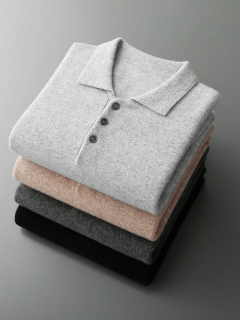 Stack of folded gray, beige, and black polo shirts on a gray background