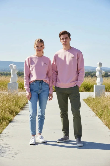 A dusty pink crewneck sweatshirt with 'Dunc' embroidered in gold on the left chest, displayed flat against a solid white background.