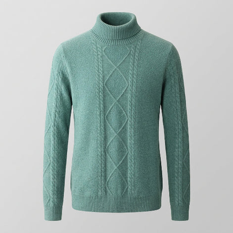 A sage green cable-knit turtleneck sweater displayed on a wooden hanger against a split gray and white studio background.