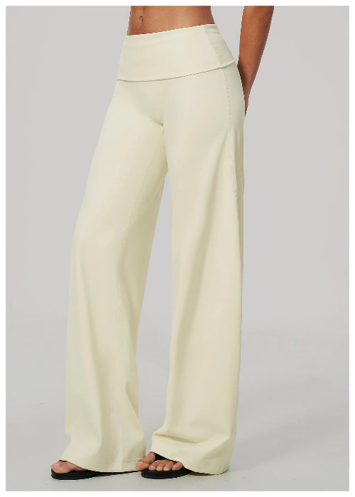 A person wearing high-waisted, wide-leg pants in a pale cream or off-white color, 