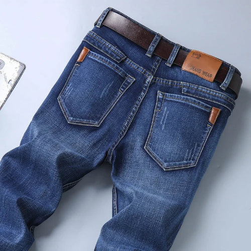 Blue jeans with a brown belt on a light gray background