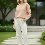 A plain crewneck sweatshirt in a warm beige or light tan color, 