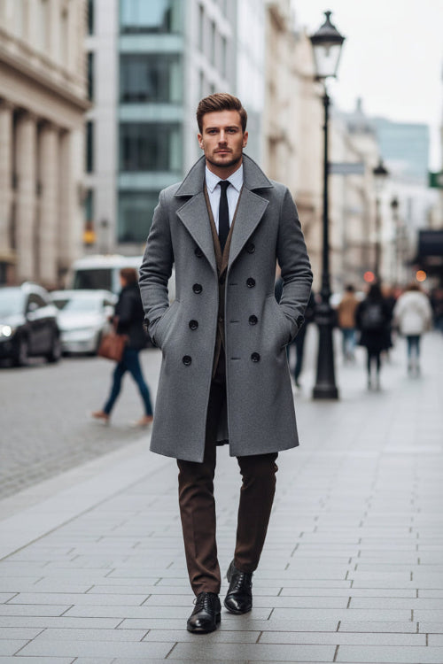 Man wearing a gray coat and brown vest on a city street
