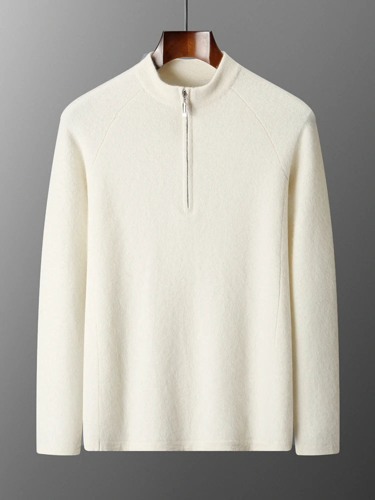 White sweater with a quarter zip on a hanger against a gray background
