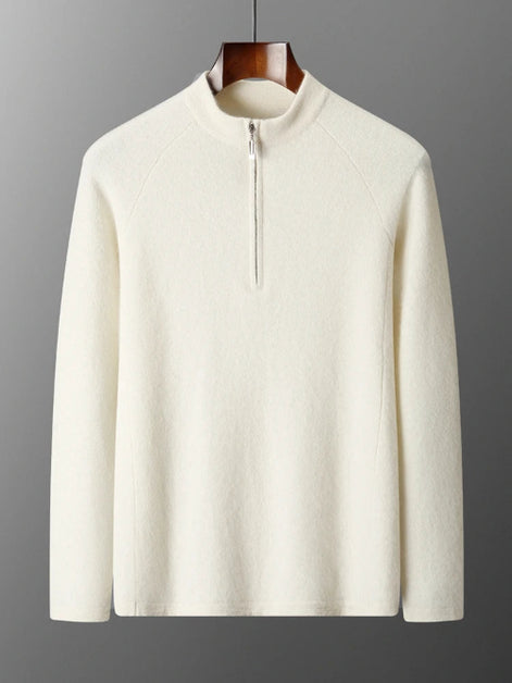 White sweater with a quarter zip on a hanger against a gray background