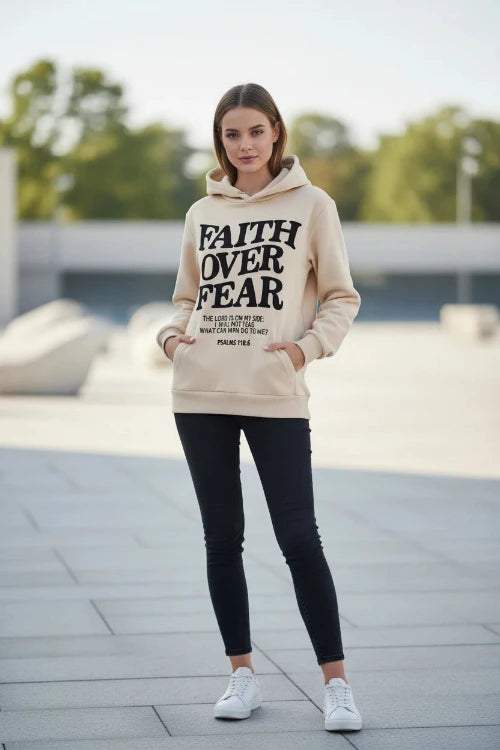 Beige hoodie with 'Faith Over Fear' text on a white surface