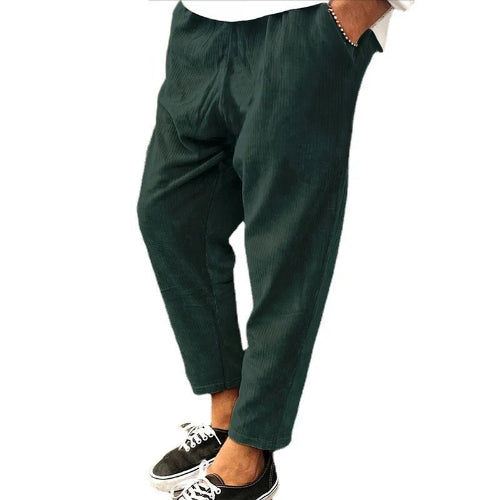 Green pants worn by a person on a white background