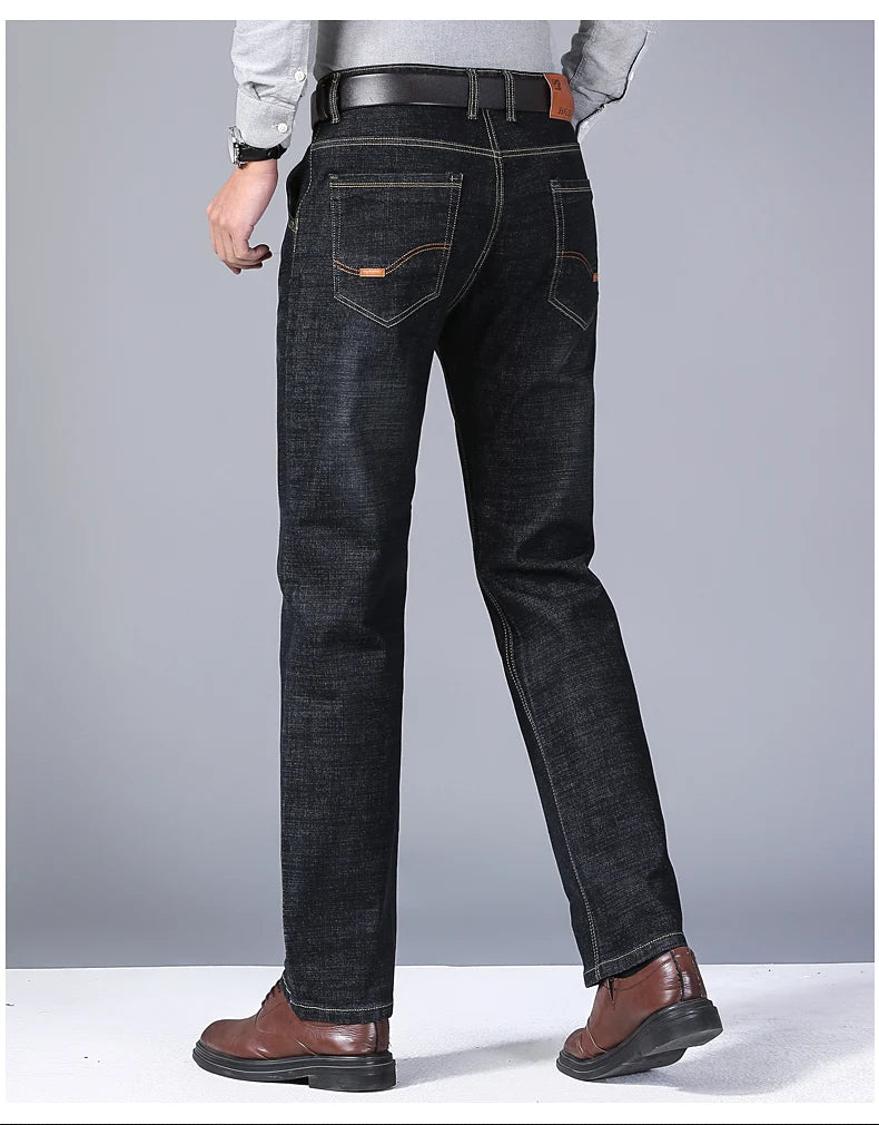 Person wearing black jeans on a gray background