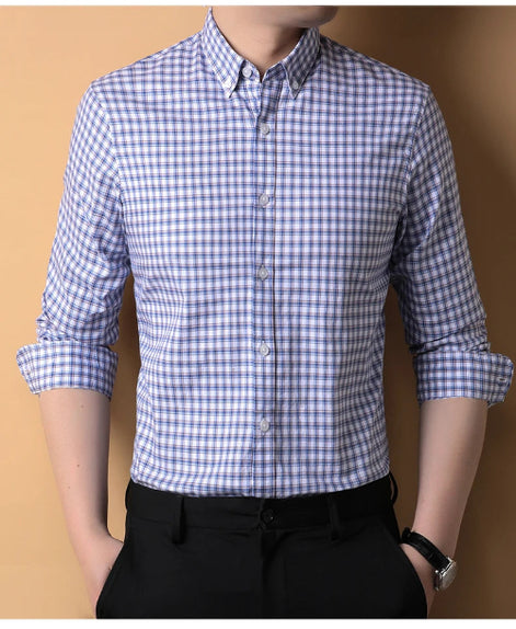 Person wearing a blue and white checkered shirt with rolled-up sleeves against a brown background
