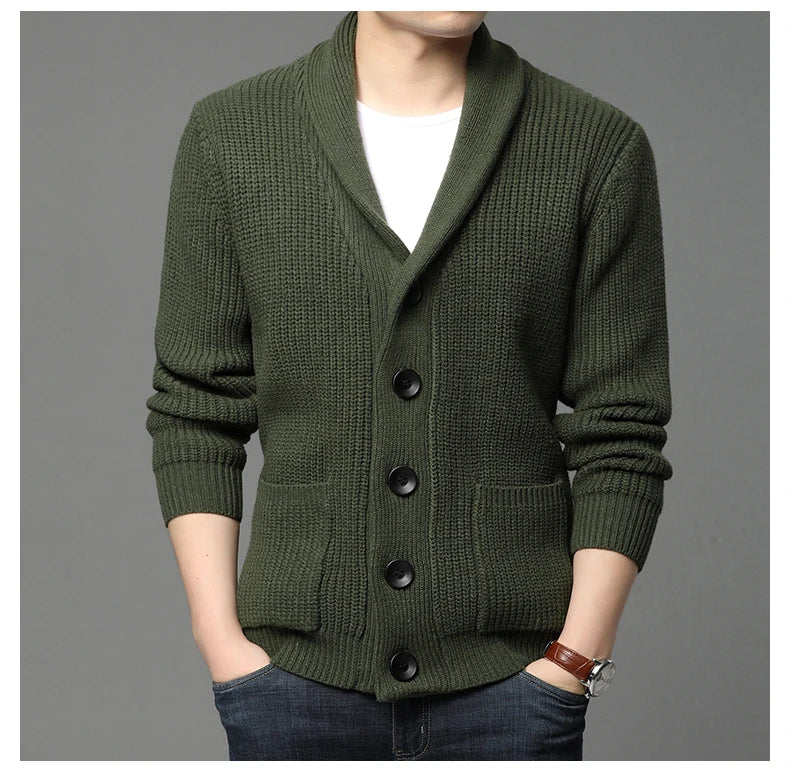 Green knitted cardigan worn by a person on a gray background
