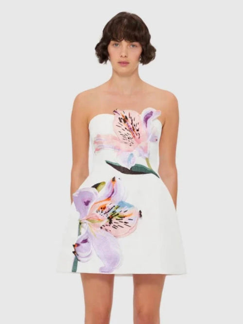 Woman wearing a strapless dress with floral design on a white background