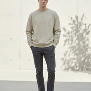 Beige sweatshirt with a small logo on a white background