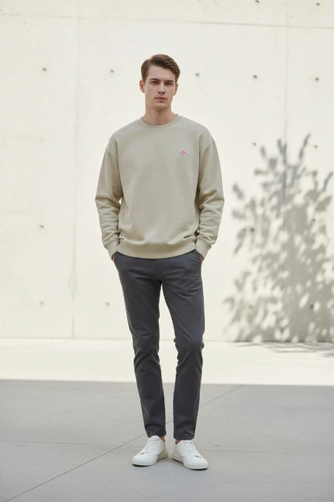 Beige sweatshirt with a small logo on a white background