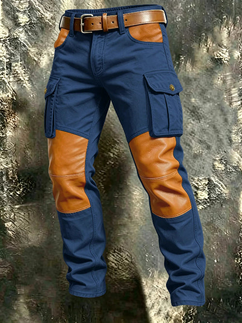 Blue cargo pants with tan contrast panels at the knees and front pockets, flap thigh pockets, and a brown belt against a textured gray background.