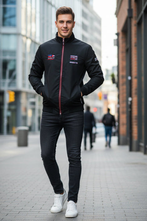 A black zip-up jacket with a high collar, featuring multiple graphic patches and logos on the front and sleeves, displayed on a white background with a TACE&SHARK 