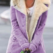 Woman outdoors wearing a purple coat with wide cream fleece-look lapels, front pockets and cuff tabs over a white top