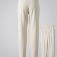 Beige suit trousers with a close-up of the legs and shoes on a dark background.
