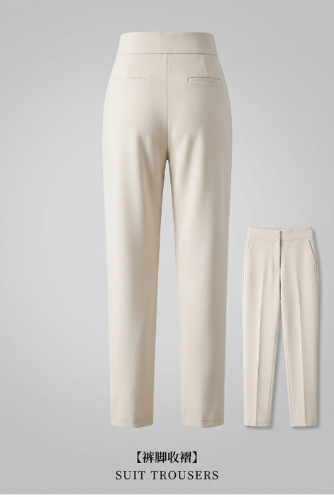 Beige suit trousers with a close-up of the legs and shoes on a dark background.