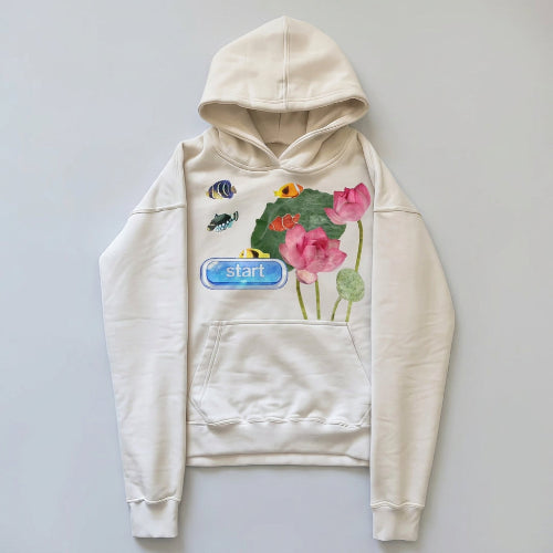 Cream graphic hoodie with pink lotus flowers, fish, and green leaves, shown flat against a light background.