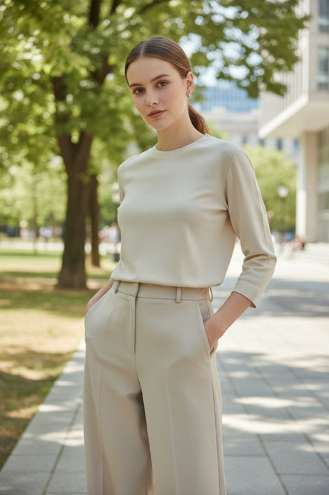 Beige long-sleeve top worn by a person against a neutral background