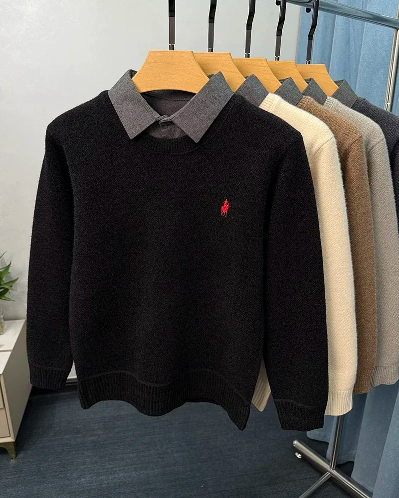 Black sweater with a red logo on a rack with other sweaters.