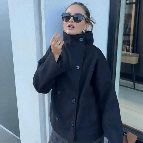 Woman wearing a dark stand-collar double-breasted short coat with a loose fit