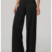 Black wide-leg cropped pants with a high-waisted wrap-style waistband, shown on a model against a light gray studio background.