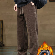 Person wearing brown corduroy pants with a flame graphic in the corner