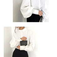 Person wearing a white shirt and black pants with a white background