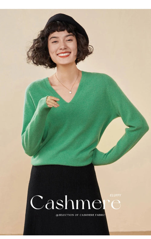 Woman wearing a green cashmere sweater with a beige background