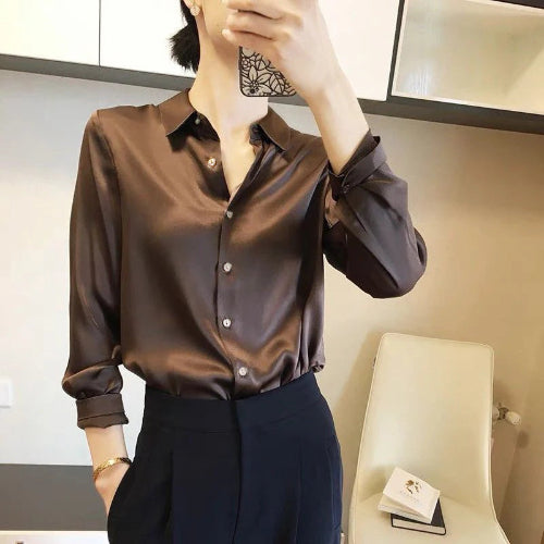 Brown satin blouse worn by a model taking a mirror selfie.