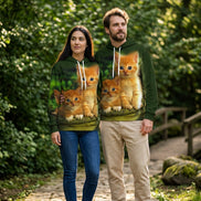 A dark green pullover hoodie featuring a large, realistic all-over print of two orange kittens sitting together, with a white hood lining and white drawstrings.