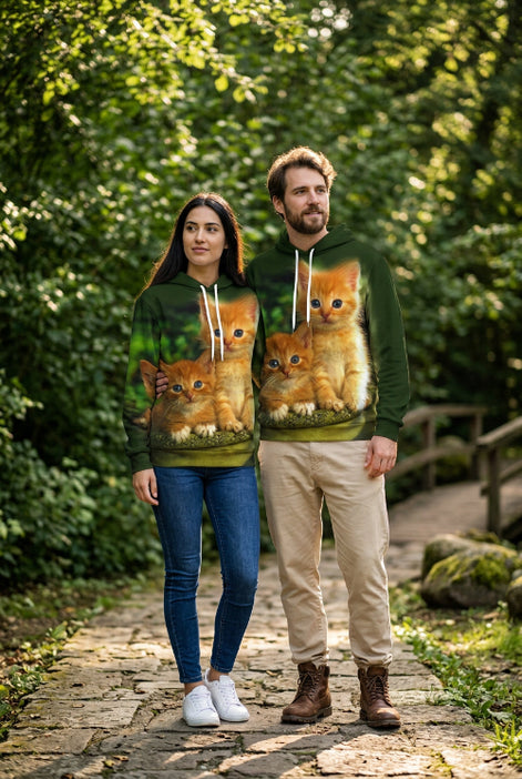 A dark green pullover hoodie featuring a large, realistic all-over print of two orange kittens sitting together, with a white hood lining and white drawstrings.