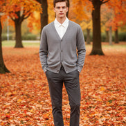 Gray cardigan over a white shirt on a wooden hanger against a wooden door background