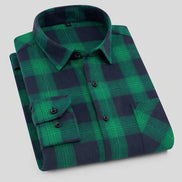 Folded green and navy plaid shirt on a white background