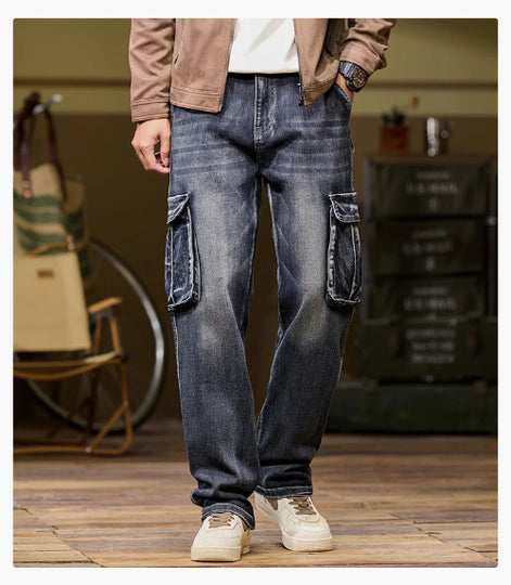Front view of a model wearing faded dark blue cargo pants with large flap thigh pockets and loose straight legs, paired with light-colored sneakers.