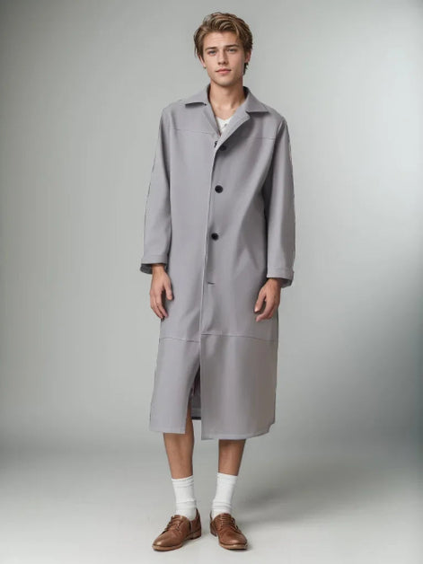 Person wearing a long gray coat on a plain background