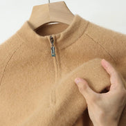 Beige fleece jacket on a hanger with a hand touching the fabric