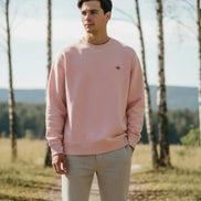 Pink sweatshirt with a small logo on a white background