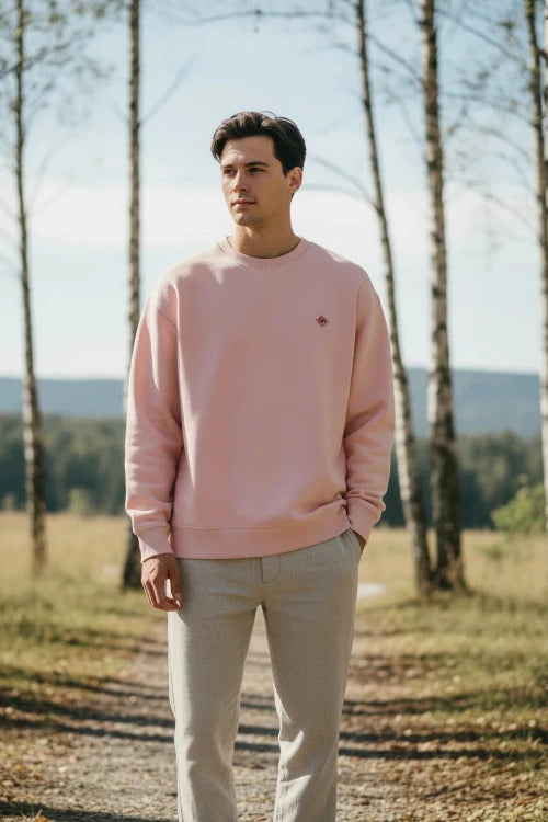 Pink sweatshirt with a small logo on a white background
