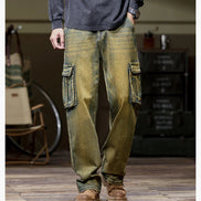 Front view of a model wearing faded olive-brown cargo pants with large flap pockets on both thighs and loose straight legs, paired with brown boots.