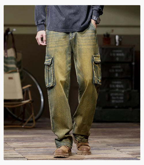 Front view of a model wearing faded olive-brown cargo pants with large flap pockets on both thighs and loose straight legs, paired with brown boots.