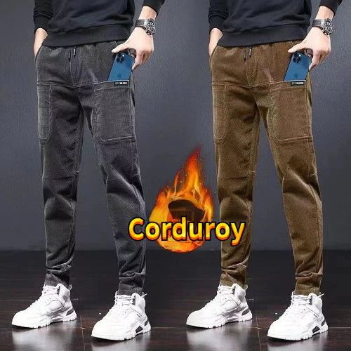 Two pairs of men's corduroy pants shown side by side, one in dark gray and one in brown, worn by a model cropped from the chest down. 