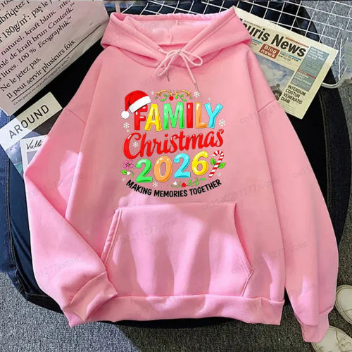 A pink pullover hoodie laid flat on a dark surface, featuring a colorful 'Family Christmas 2026' graphic 